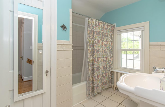 bathroom featuring radiator, tile patterned floors, tile walls, a wainscoted wall, and shower / bath combo