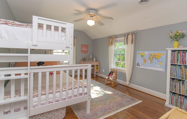 bedroom featuring lofted ceiling, baseboards, and wood finished floors