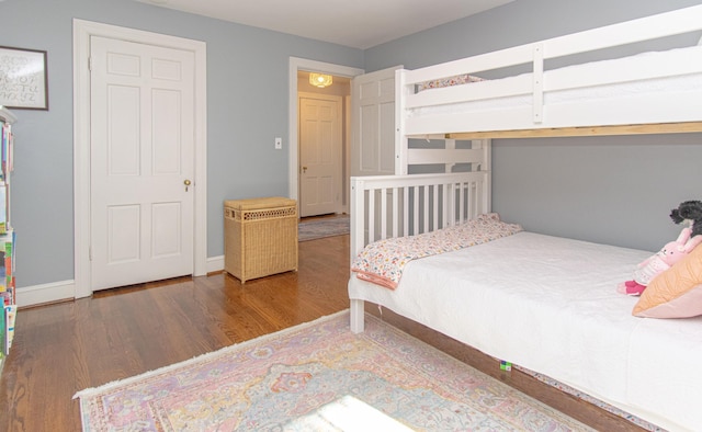 bedroom featuring wood finished floors and baseboards