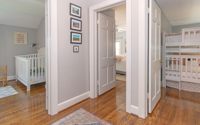 corridor with wood finished floors and baseboards