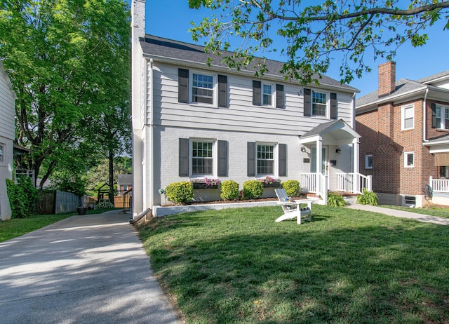 view of front of house featuring concrete driveway, a chimney, and brick siding