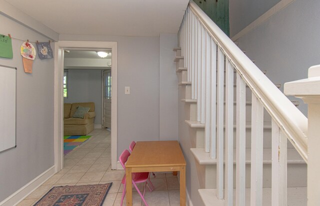 stairway with tile patterned floors and baseboards