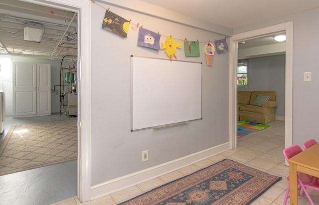 hallway featuring tile patterned flooring and baseboards