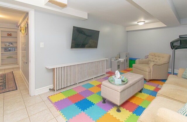 game room with radiator heating unit, tile patterned floors, baseboards, and built in shelves