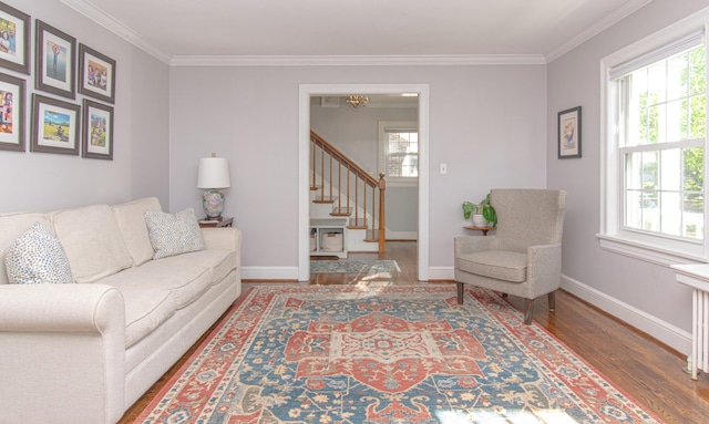 living room with crown molding, wood finished floors, stairway, and baseboards