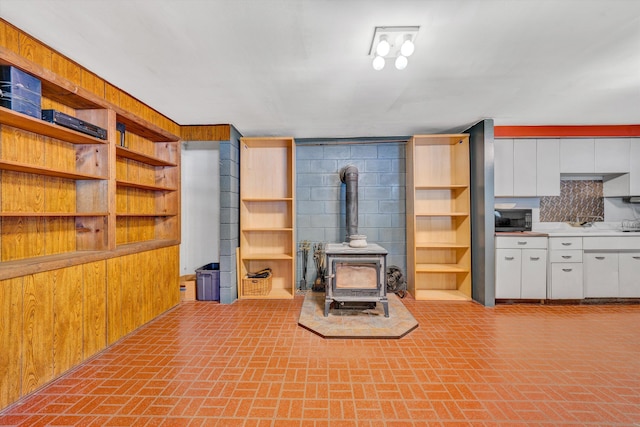 3553 Kidder Ln, Salem, VA 24153 - unfurnished living room with brick patterned flooring, a wood stove, and wood walls