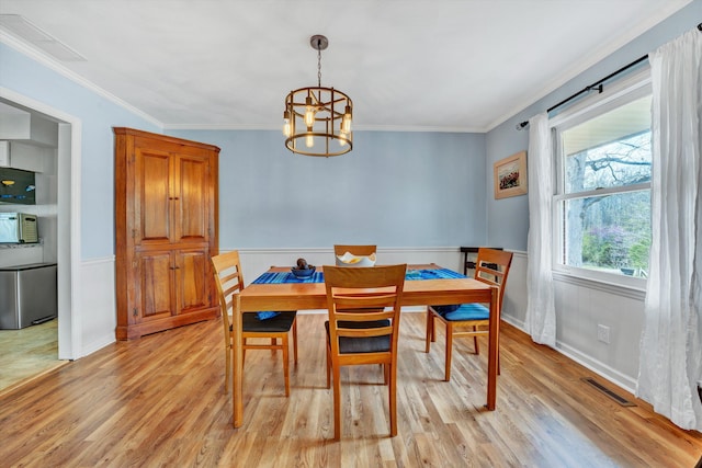 3553 Kidder Ln, Salem, VA 24153 - dining space with light wood-style flooring, a chandelier, a wainscoted wall, and crown molding