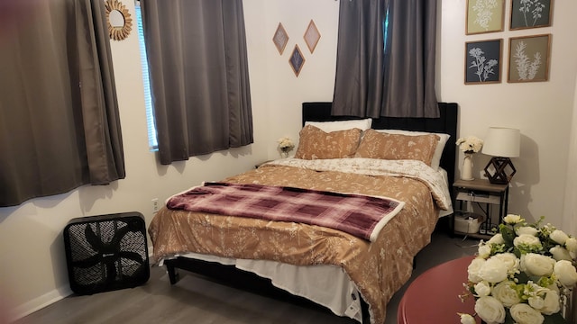 bedroom featuring baseboards and wood finished floors