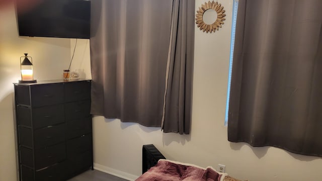 bedroom featuring baseboards and radiator