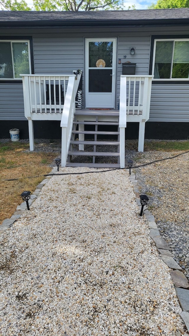 view of exterior entry featuring a wooden deck