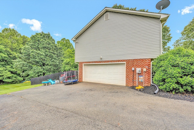 60 Surber Dr, Moneta, VA 24121 - view of property exterior with asphalt driveway, an attached garage, brick siding, and fence
