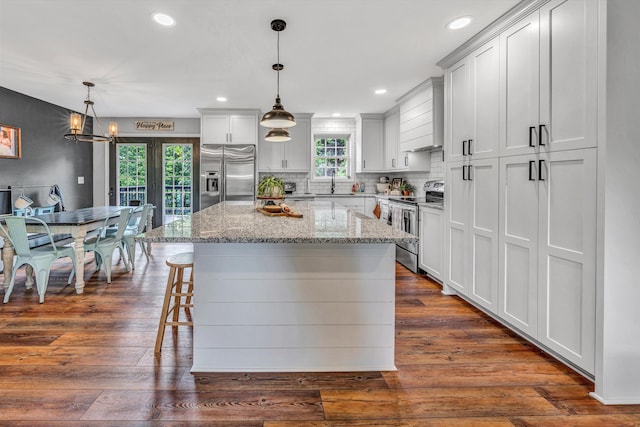 60 Surber Dr, Moneta, VA 24121 - kitchen with stainless steel appliances, a kitchen island, light stone countertops, a kitchen bar, and dark wood finished floors