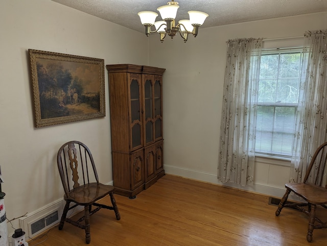 1987 Franklin St, Rocky Mount, VA 24151 - living area featuring light wood-style floors, a chandelier, baseboards, and a textured ceiling