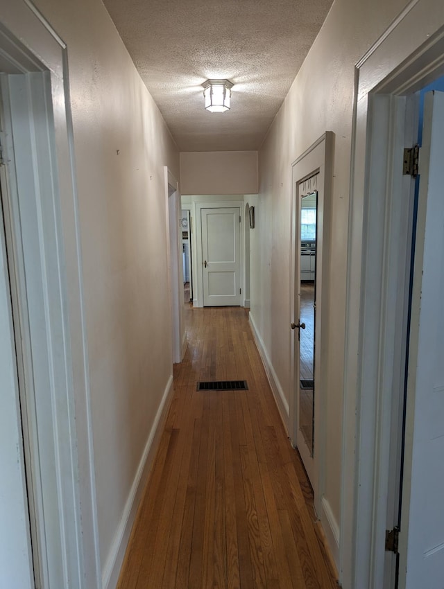 1987 Franklin St, Rocky Mount, VA 24151 - hall with a textured ceiling, wood-type flooring, and baseboards