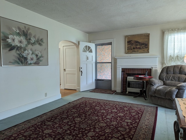 1987 Franklin St, Rocky Mount, VA 24151 - living room with a textured ceiling, carpet, arched walkways, and a fireplace