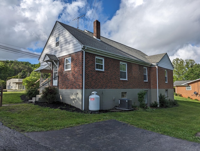 1987 Franklin St, Rocky Mount, VA 24151 - view of property exterior with brick siding, a chimney, a lawn, central AC unit, and a shingled roof