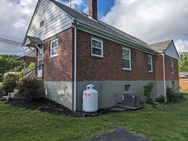 1987 Franklin St, Rocky Mount, VA 24151 - view of property exterior with brick siding, cooling unit, a chimney, and a lawn
