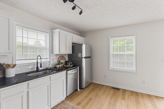 1503 Cassell Ln, Bedford, VA 24523 - kitchen featuring a sink, appliances with stainless steel finishes, decorative backsplash, light wood-type flooring, and white cabinetry