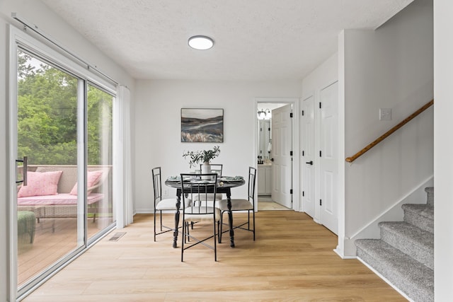 1503 Cassell Ln, Bedford, VA 24523 - dining area with light wood finished floors, stairway, a textured ceiling, and baseboards
