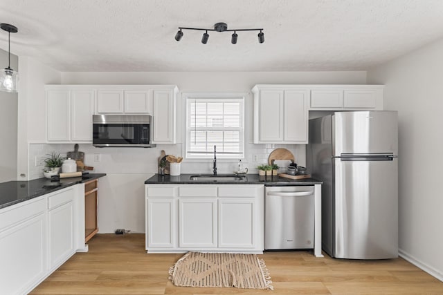 1503 Cassell Ln, Bedford, VA 24523 - kitchen featuring stainless steel appliances, a sink, backsplash, white cabinetry, and a textured ceiling