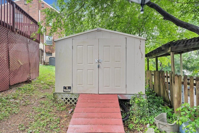 view of shed with fence and central AC unit