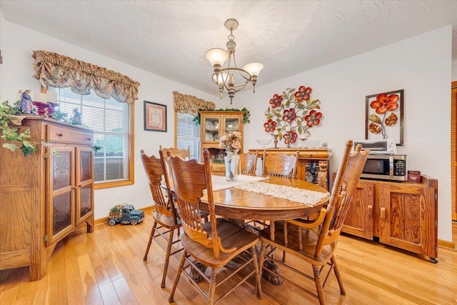 338 White Oak Ln, New Castle, VA 24127 - dining room featuring a chandelier, light wood-style flooring, and baseboards
