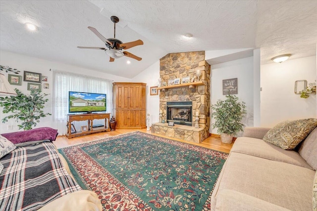 338 White Oak Ln, New Castle, VA 24127 - living room featuring a ceiling fan, light wood-style floors, vaulted ceiling, a fireplace, and a textured ceiling