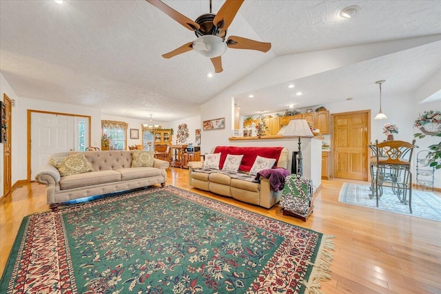 338 White Oak Ln, New Castle, VA 24127 - living area featuring lofted ceiling, a ceiling fan, light wood-type flooring, a chandelier, and a textured ceiling
