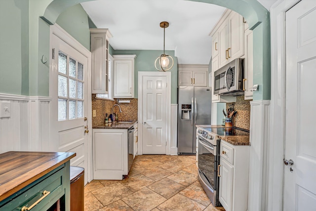 2408 Avenham Ave SW, Roanoke, VA 24014 - kitchen featuring appliances with stainless steel finishes, a sink, tasteful backsplash, arched walkways, and a wainscoted wall