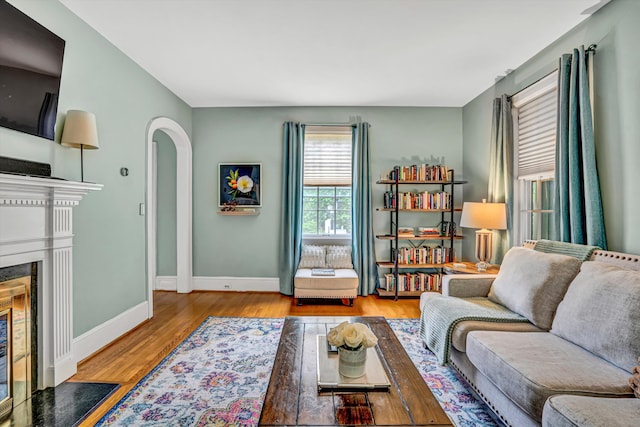 2408 Avenham Ave SW, Roanoke, VA 24014 - living room featuring wood finished floors, arched walkways, baseboards, and a fireplace with flush hearth