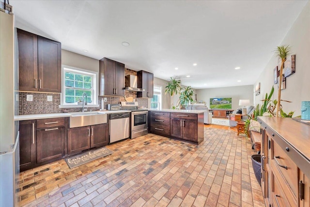 414 Mallard Cove Rd, Moneta, VA 24121 - kitchen featuring appliances with stainless steel finishes, wall chimney exhaust hood, a peninsula, a sink, and tasteful backsplash