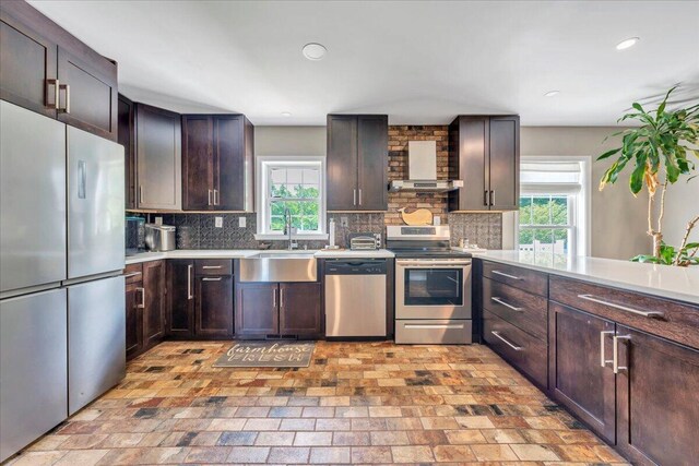 414 Mallard Cove Rd, Moneta, VA 24121 - kitchen featuring stainless steel appliances, a sink, backsplash, wall chimney range hood, and brick patterned flooring