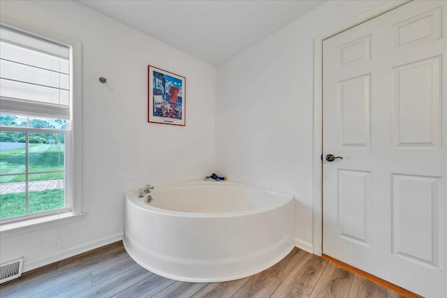 414 Mallard Cove Rd, Moneta, VA 24121 - bathroom with a bath, wood finished floors, and baseboards
