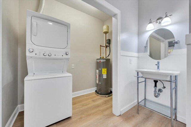 2521 Feather Garden Cir, Vinton, VA 24179 - bathroom featuring water heater, stacked washer and clothes dryer, wood finished floors, baseboards, and a sink