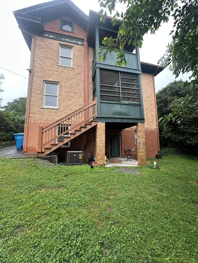 2319 Avenham Ave SW, Roanoke, VA 24014 - back of property with central AC unit, brick siding, and a patio