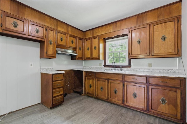 66 Adrian St, Bassett, VA 24055 - kitchen featuring a sink, under cabinet range hood, brown cabinetry, and light wood-type flooring
