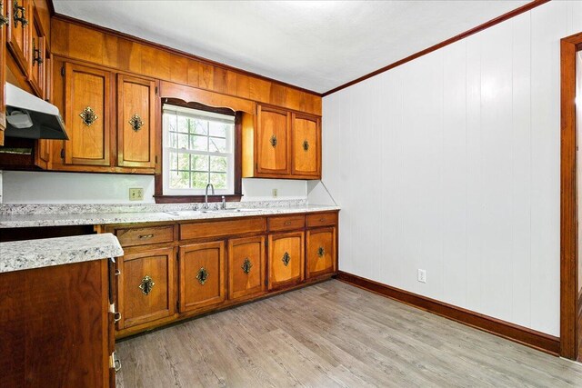 66 Adrian St, Bassett, VA 24055 - kitchen featuring brown cabinets, ornamental molding, a sink, light countertops, and light wood-type flooring