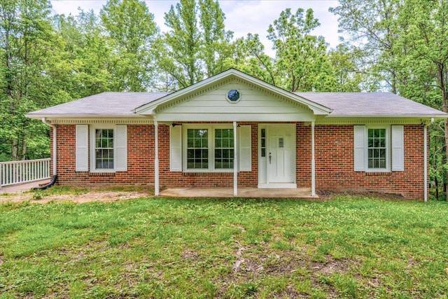 ranch-style house with brick siding, roof with shingles, and a front yard