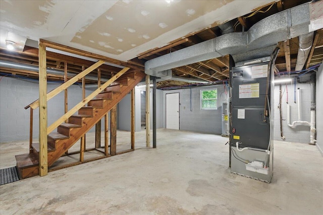 below grade area with water heater, stairs, and heating unit