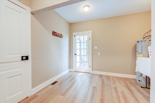 entryway featuring water heater, wood finished floors, and baseboards