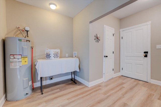 entrance foyer with electric water heater, light wood-type flooring, and baseboards