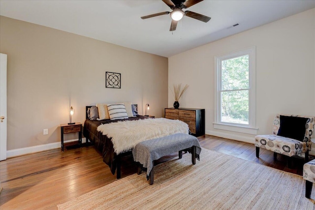 bedroom featuring wood finished floors, baseboards, and ceiling fan