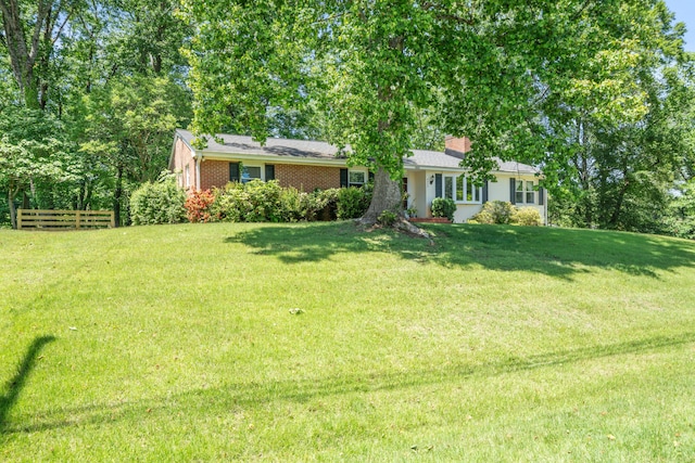 single story home with brick siding and a chimney