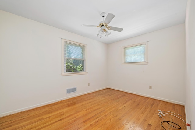 spare room with plenty of natural light, baseboards, and light wood-style floors