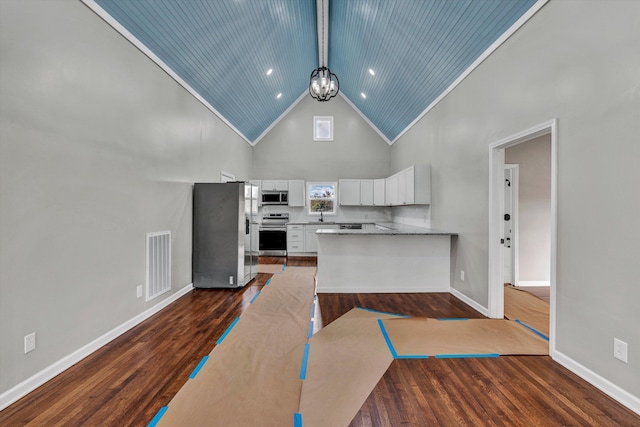 475 S Main St, Rocky Mount, VA 24151 - kitchen with stainless steel appliances, high vaulted ceiling, white cabinets, a chandelier, and dark wood finished floors