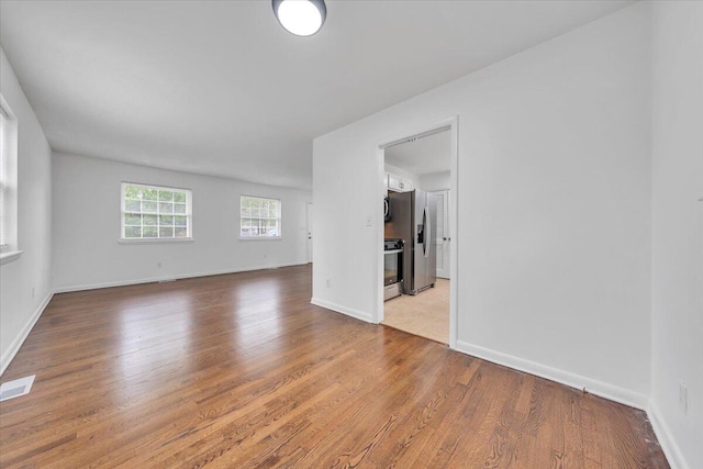 spare room featuring wood finished floors and baseboards