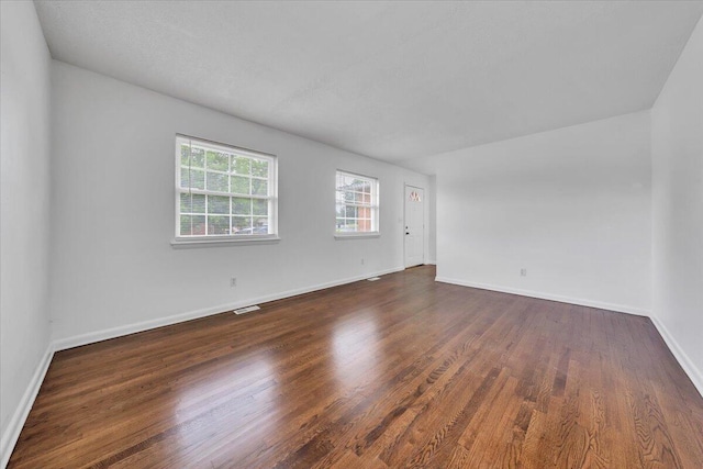 unfurnished room featuring dark wood-style floors and baseboards