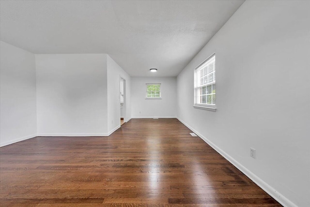spare room with dark wood finished floors and baseboards
