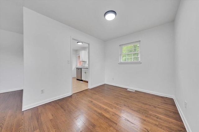 spare room with wood finished floors and baseboards