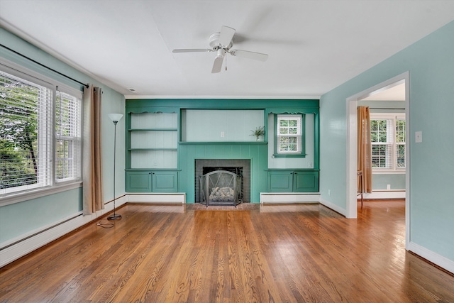 2848 Longview Ave SW, Roanoke, VA 24014 - unfurnished living room with baseboard heating, a brick fireplace, wood finished floors, baseboards, and ceiling fan